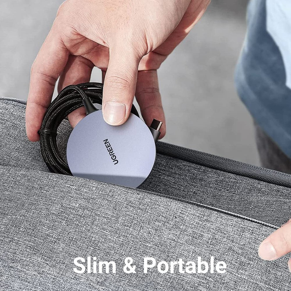 Hand tucking the Ugreen 30233 charger and its coiled cable into a grey bag pocket